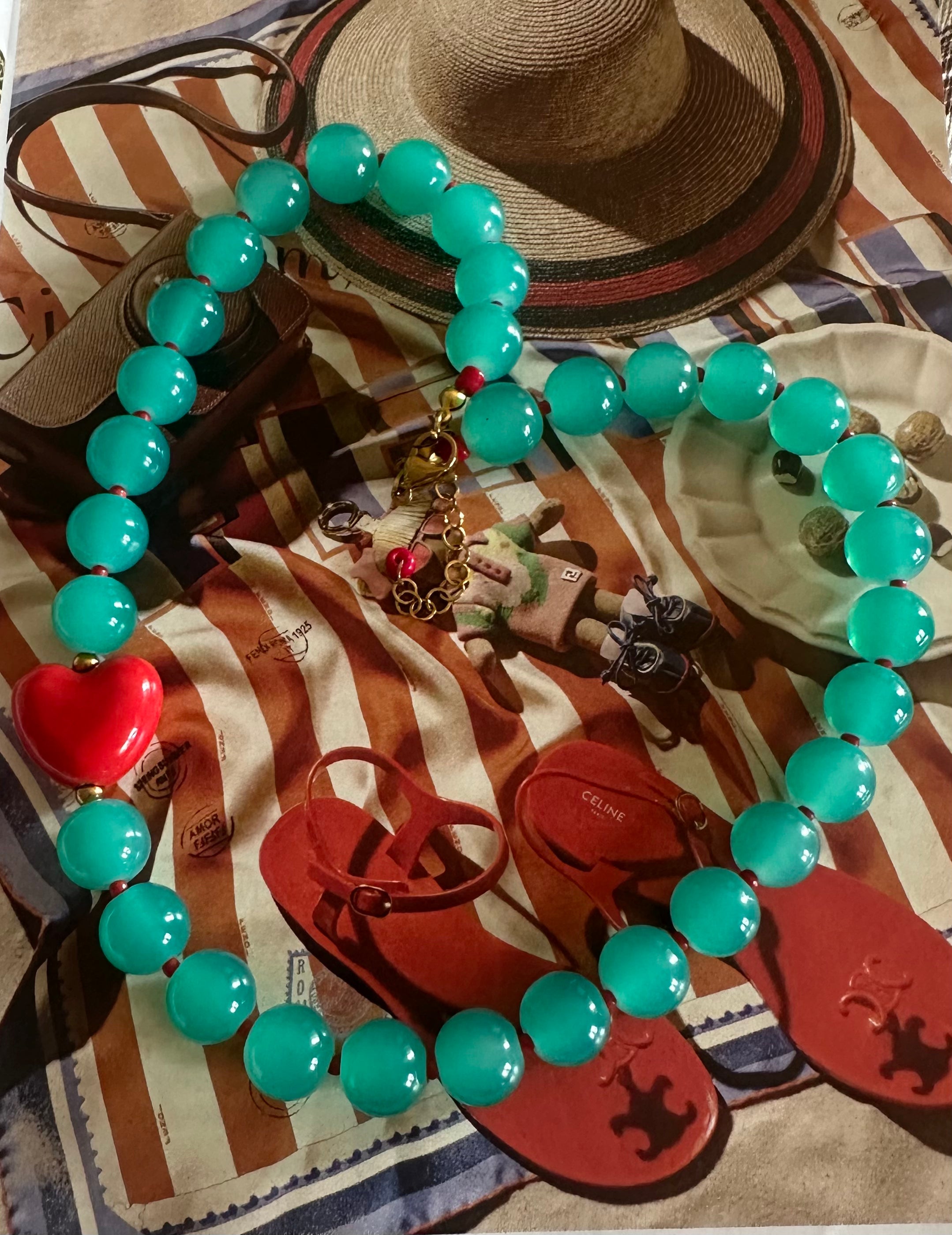 Collar cristal turquesa con corazones rojo.