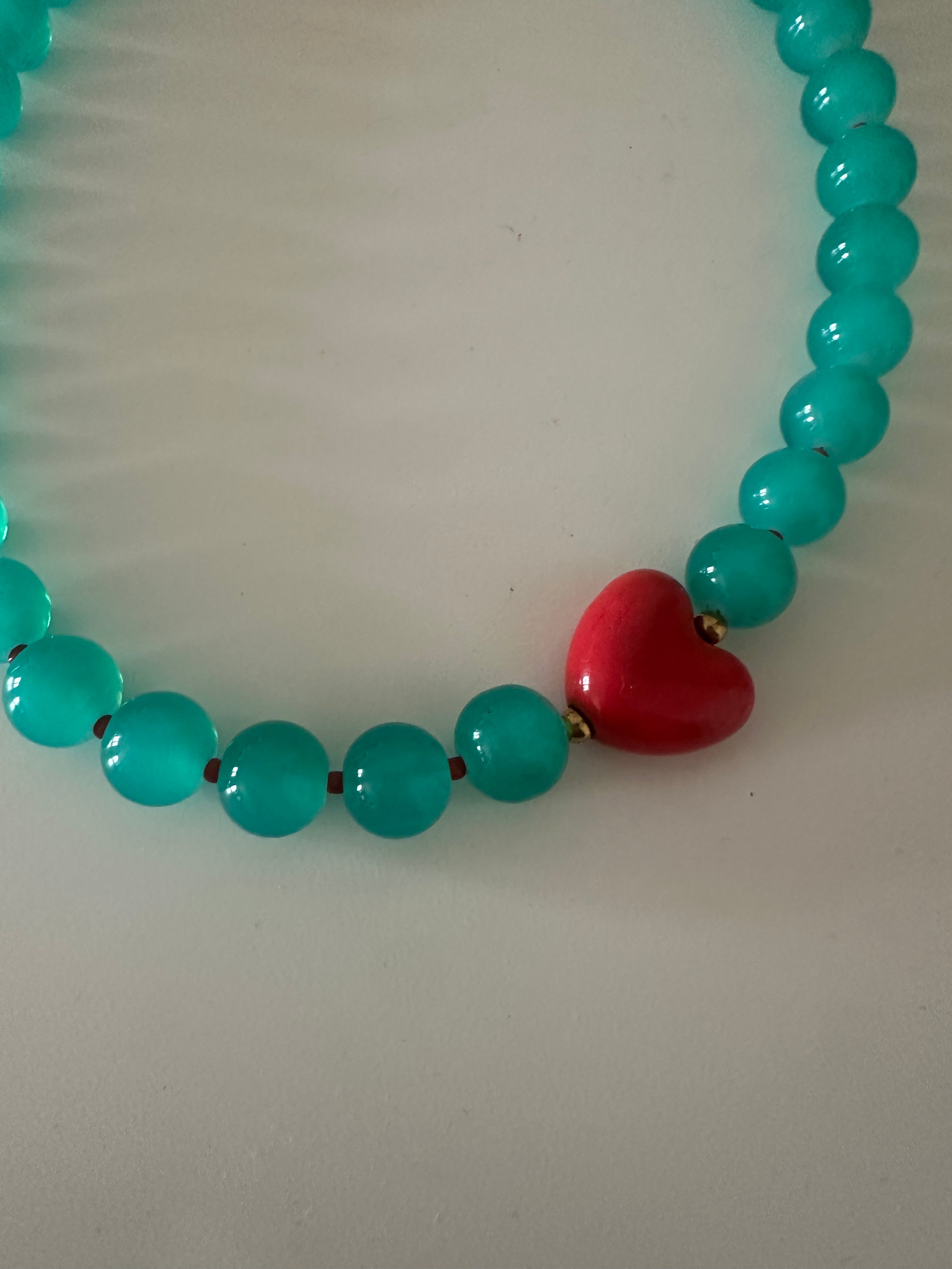 Collar cristal turquesa con corazones rojo.